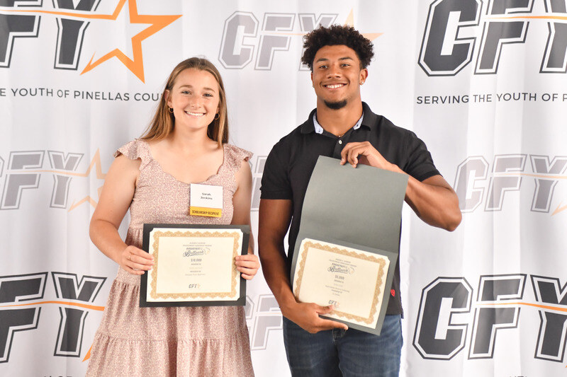 CFY scholarship recipients holding award certificates at recognition event.