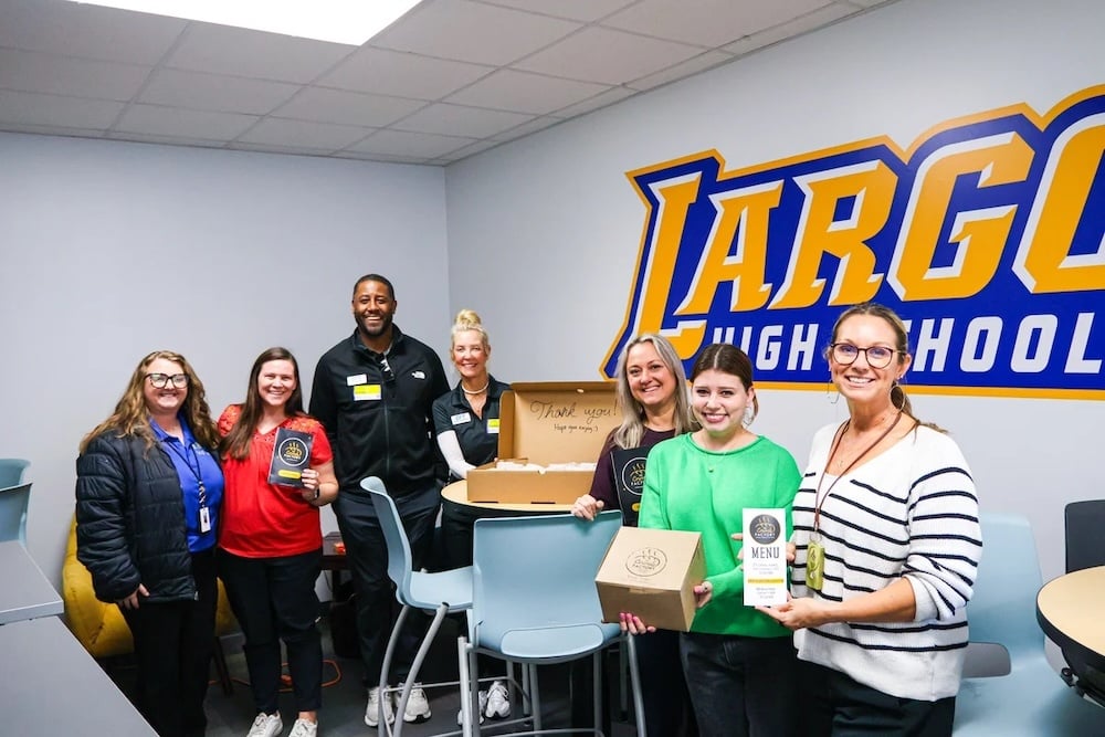 Scholar recipients holding bake goods from The Crumbs Factory at Largo High School