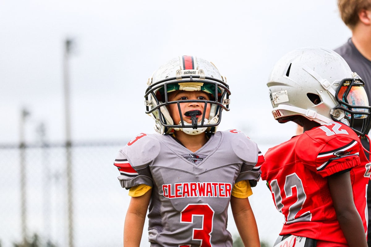 Youth football players from the Clearwater Jr. Tornadoes on the field in Clearwater, Florida, playing football.
