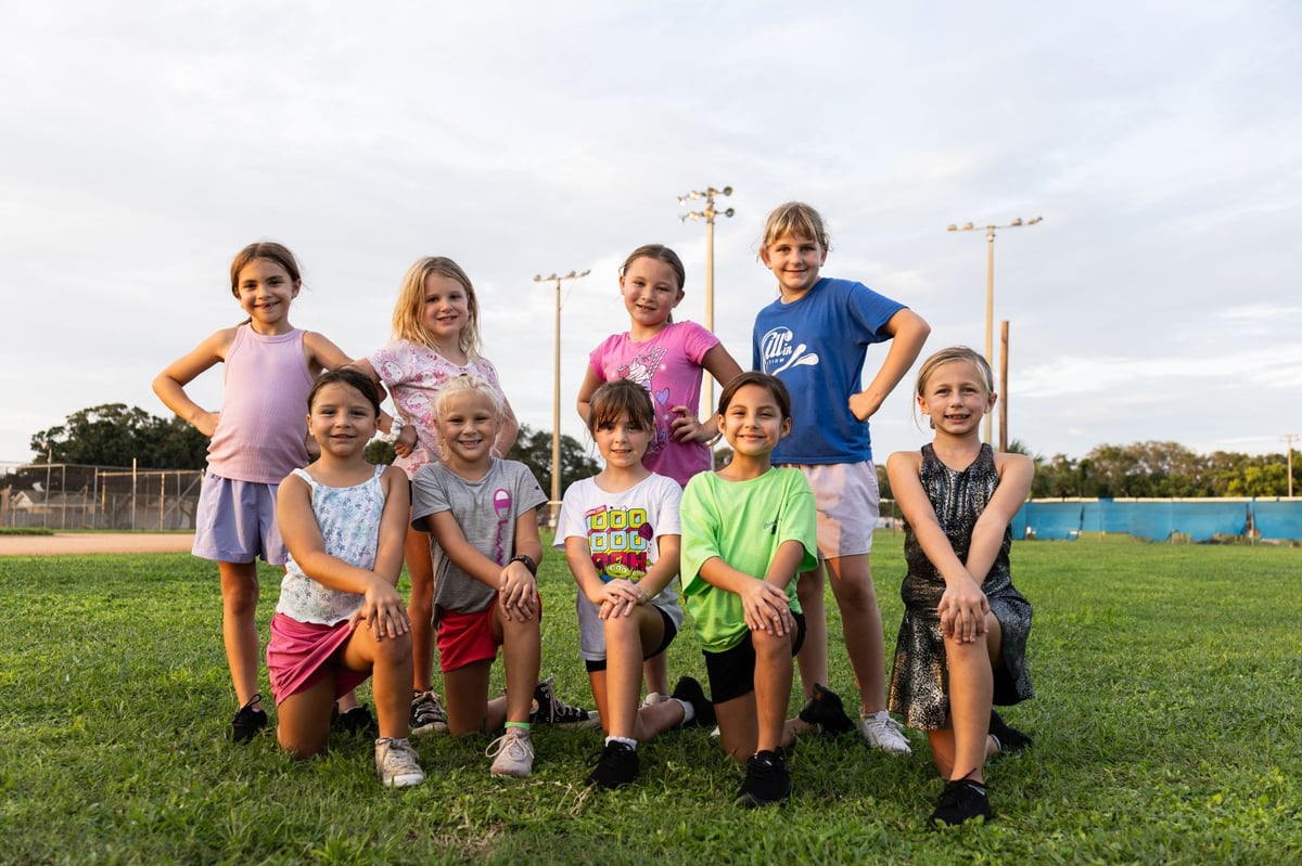 Seminole Seahawks youth cheerleaders posing for a picture on the outdoor football field. 