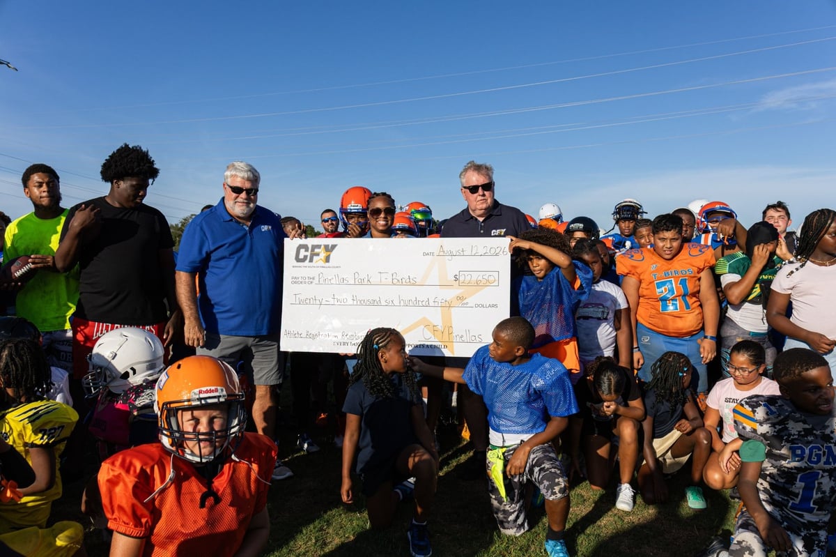 Pinellas Park T-Birds youth football team holding the grant check for CFY Pinellas.