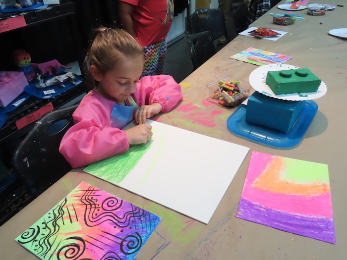 Child drawing during an arts activity at CFYs arts school program.