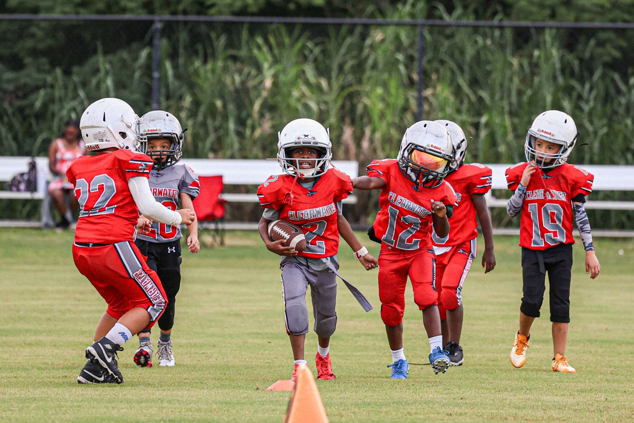 Pinellas County youth football team playing football on an outdoor field. 